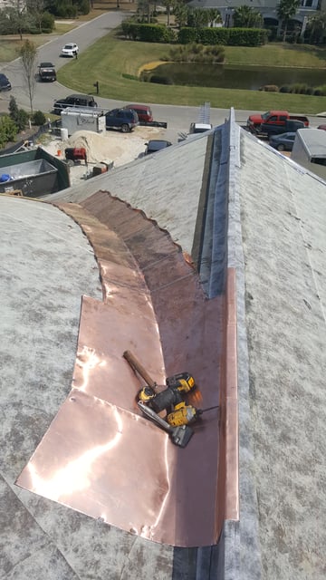 copper flashing cascading down roof