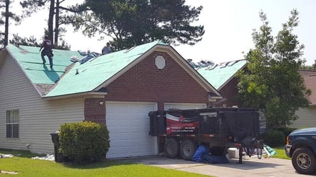 roofing dump trailer in front of a home getting a new roof