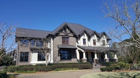 Brick and stucco home with brown metal roof