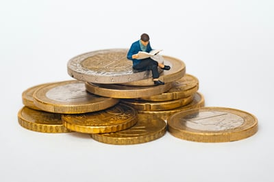 Guy sitting on a stack of giant coins reading a book, learning how to protect his money