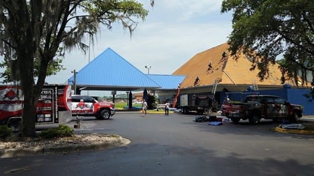 Commercial roofers installing a blue standing seam metal roof