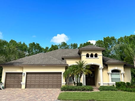 Contrast yellow stucco, GAF Weatherwood shingles with dark brown garage doors