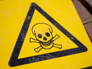 yellow danger triangle symbol with a pirate skull and cross bones in the center