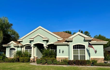 Seafoam color stucco with cultured stone and a GAF Timberline HDZ shakewood shingle roof