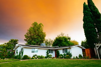 Gable style roof on a one-story ranch with a bright orange sunset