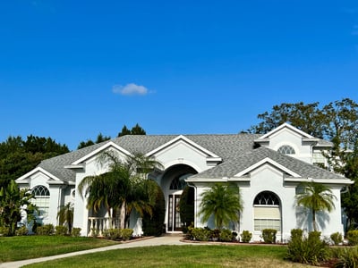 Stucco home with a Hip and gable roof with a blended color scheme
