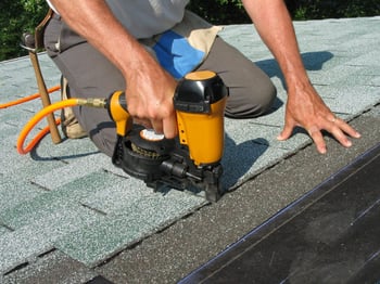 Roofer installing asphalt shingle roof