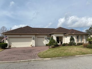 ranch-style stucco home with a hip shingle roof 