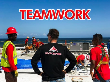 commercial roofing company tearing off a flat roof with the text teamwork on the image 