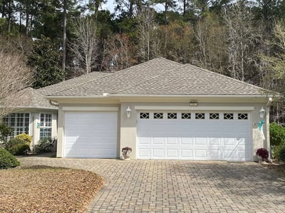 Stucco home with 3 car garage and asphalt shingle roof