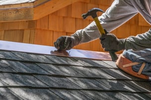 roofer installing copper flashing on shingles