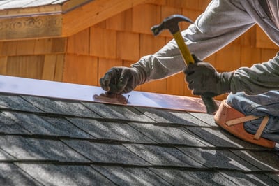 roofer installing copper flashing on shingles