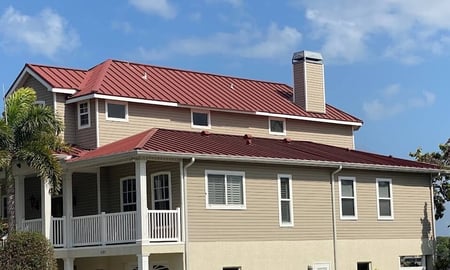 large home with colonial red, aluminum standing seam metal roof