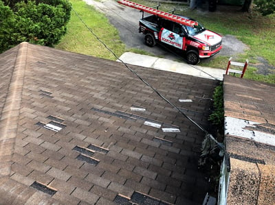 rooftop shot of missing shingles and Jacksonville RoofCrafters truck