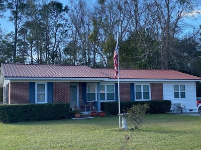 red screw-down metal roof on brick home