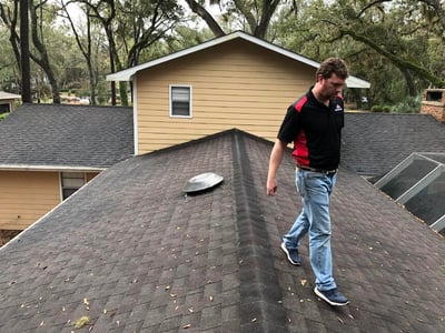 roof estimator inspecting an asphalt shingle roof