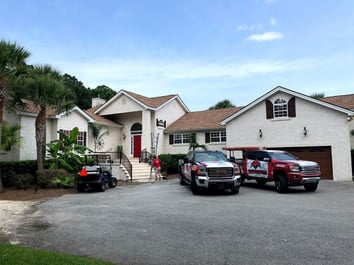 roof replacement in progress with RoofCrafters trucks in driveway