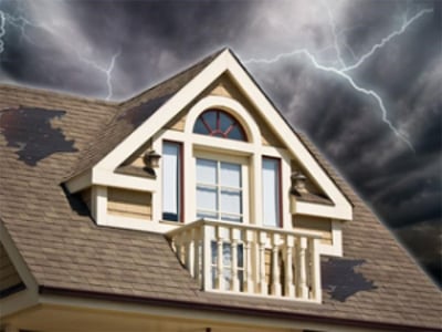 stormy skies with wind damage shingle roof