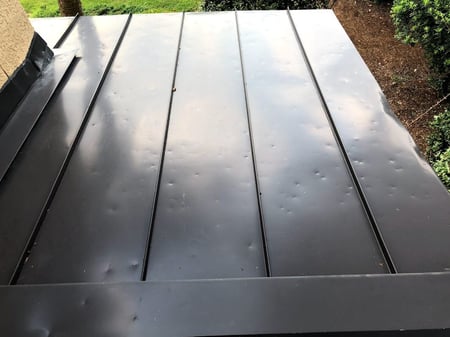 Standing seam metal roof with hail damage