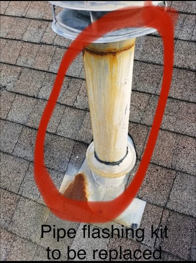 rusted metal pipe vent on a shingle roof