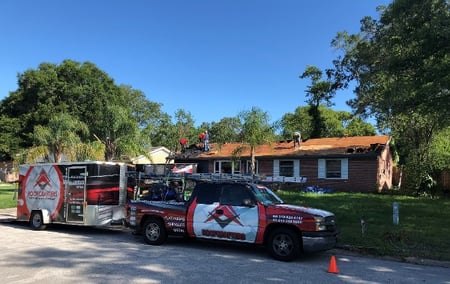 RoofCrafters Truck and Trailer in front of a shingle roof replacement