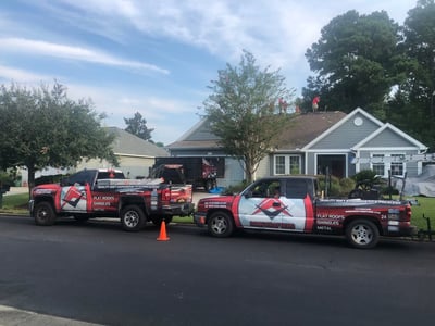 RoofCrafters Trucks parked in front of a home getting a roof replacement