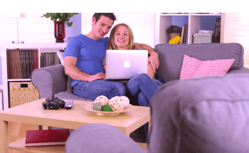 Couple relaxing on a  couch in their living room ordering a virtual roof estimate
