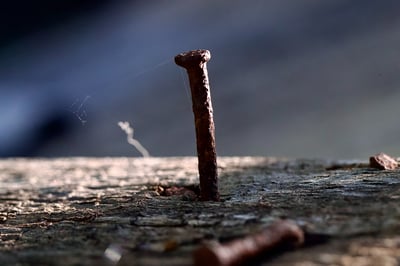 rusted nail backing out of a roof