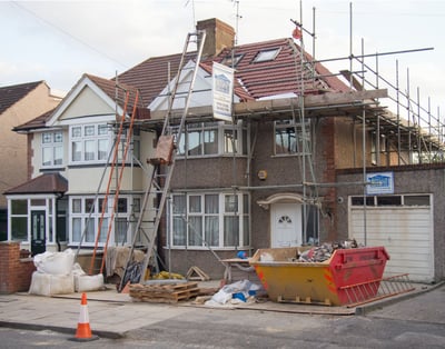 Scaffolding around a new home being built with a tile roof