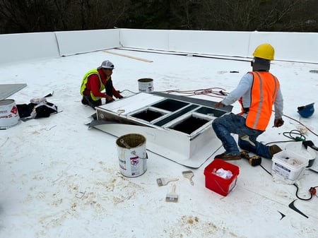 2 roofers installing TPO on commercial building
