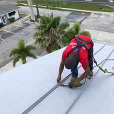 roofer welding faux seams on a gray TPO roof