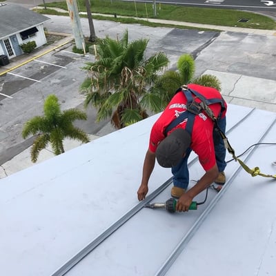 roofer welding faux seams on a gray TPO roof