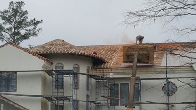 New tile roof being installed on a stucco home