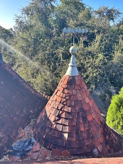 Ols Ludowici flat clay tiles on a turret roof with a copper spire 
