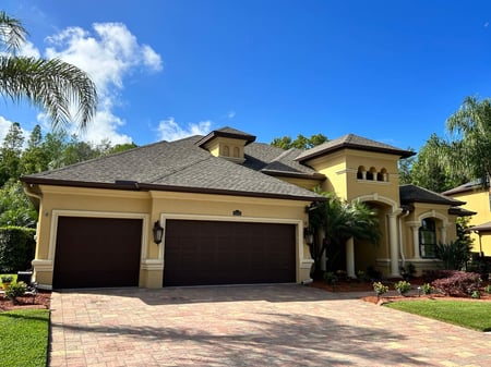 Yellow stucco home with GAF weatherwood shingles