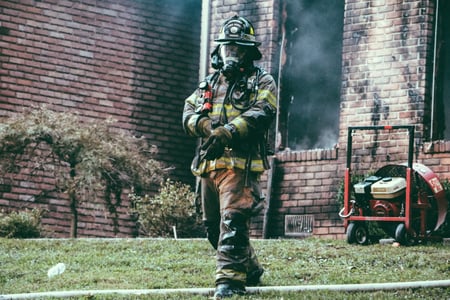 firefighter outside burning home