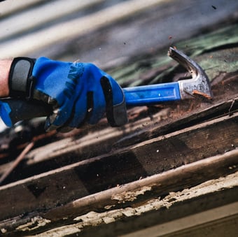 fixing roof with hammer and glove