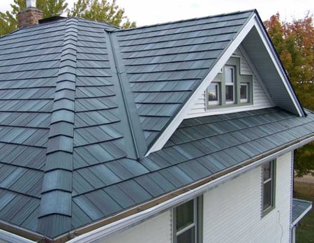 blue-gray metal shingles on a 2-story hip and gable-style roof up close 