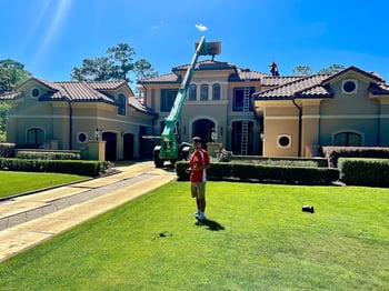 roofer flying a drone in front of a beautiful Spanish style home getting a new tile roof