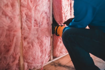 pink insulation with an inspector measuring