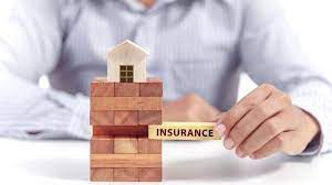 man holding an insurance sign with a model home