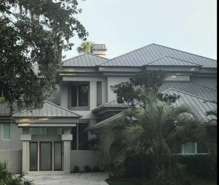 large modern home with standing seam hip roof