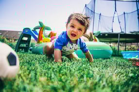 baby playing with yard toys