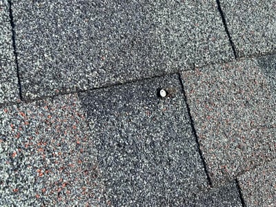 nail backing up through an asphalt shingle