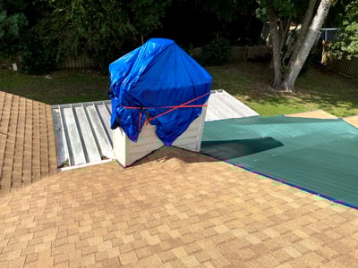 poor installation on a new roof, tarps on the chimney and roof