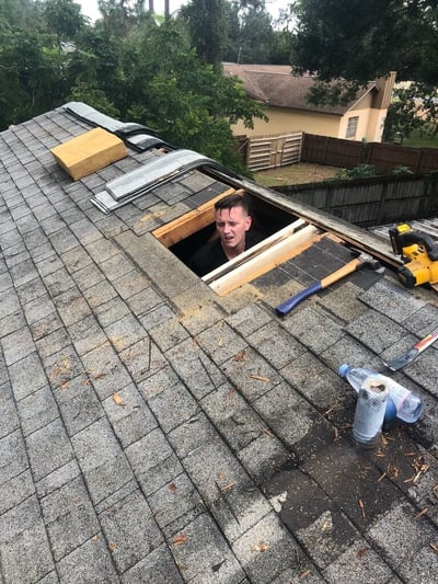 roofer in the attic repairing damaged wood