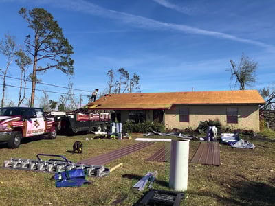 RoofCrafters truck in the driveway of a metal roof replacement project