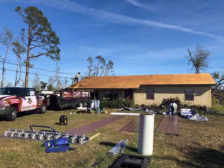 RoofCrafters truck in the driveway of a metal roof replacement project