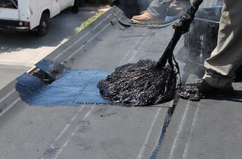 hot tar being mopped on a flat roof