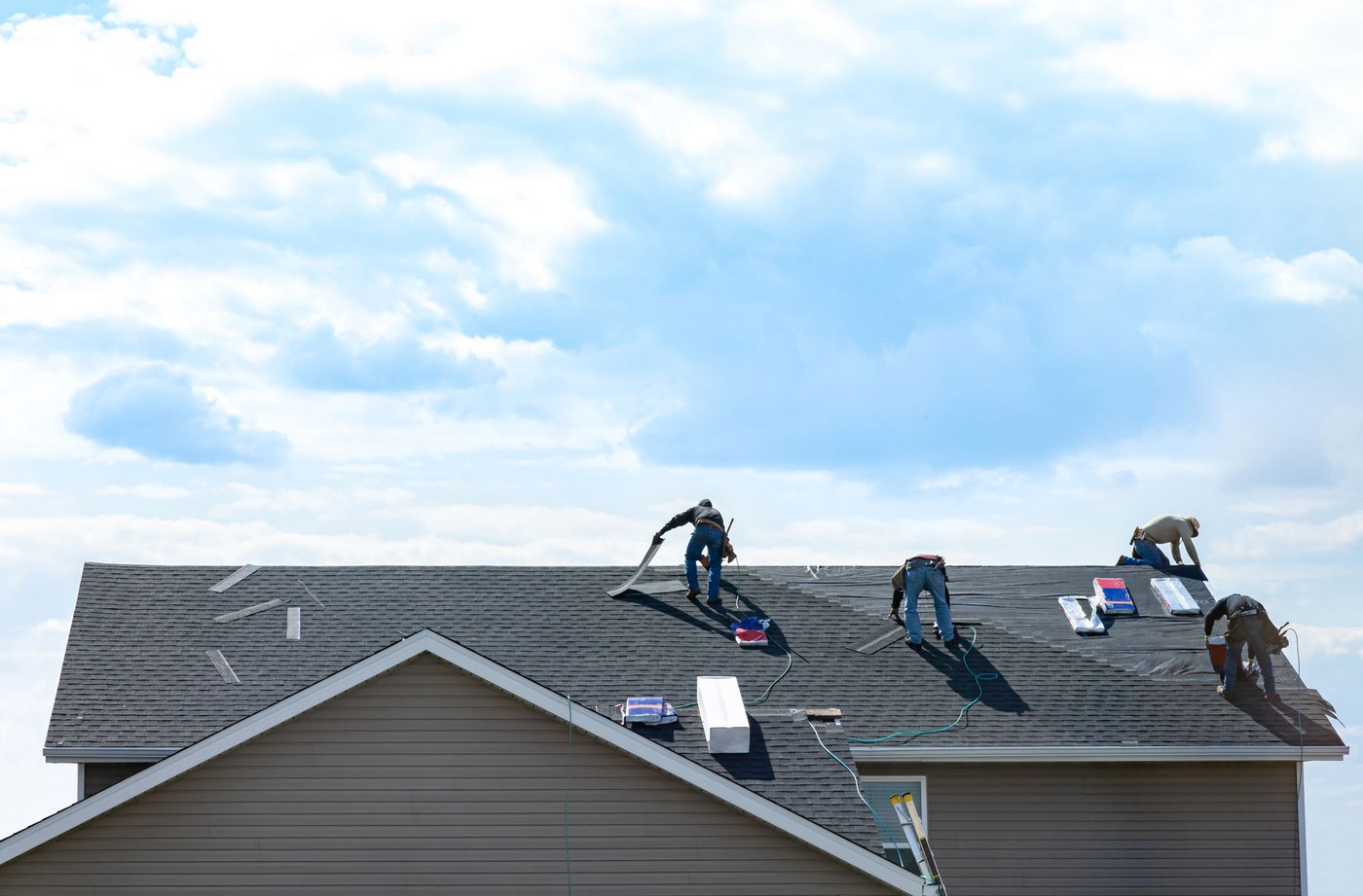 Professional roofing team repairing asphalt shingles on roof